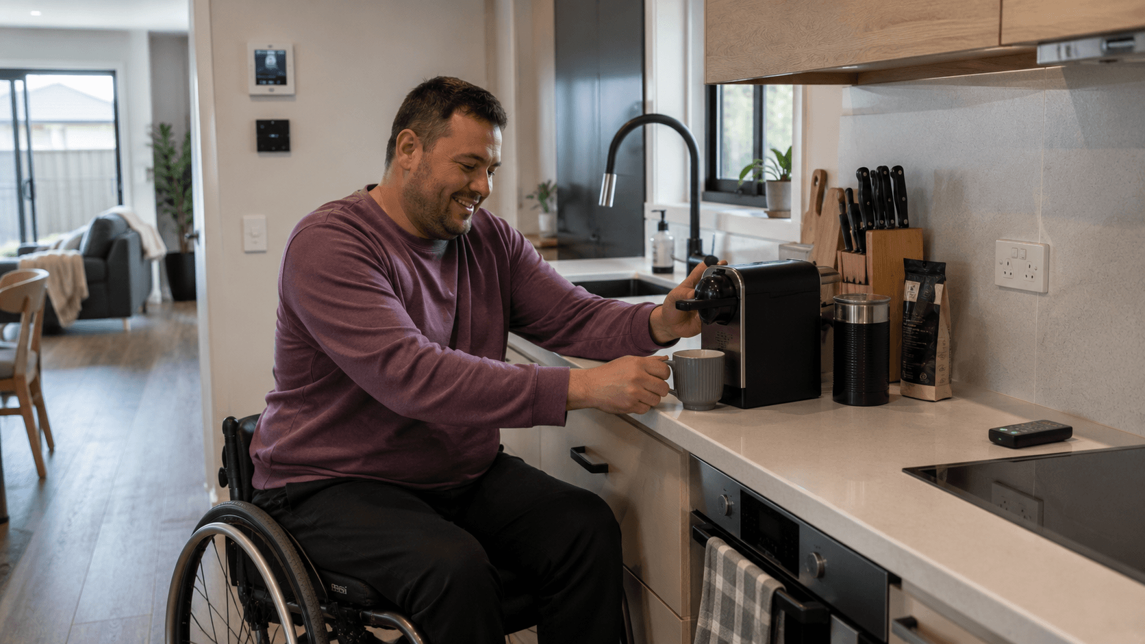 A wheelchair user making coffee in an accessible kitchen