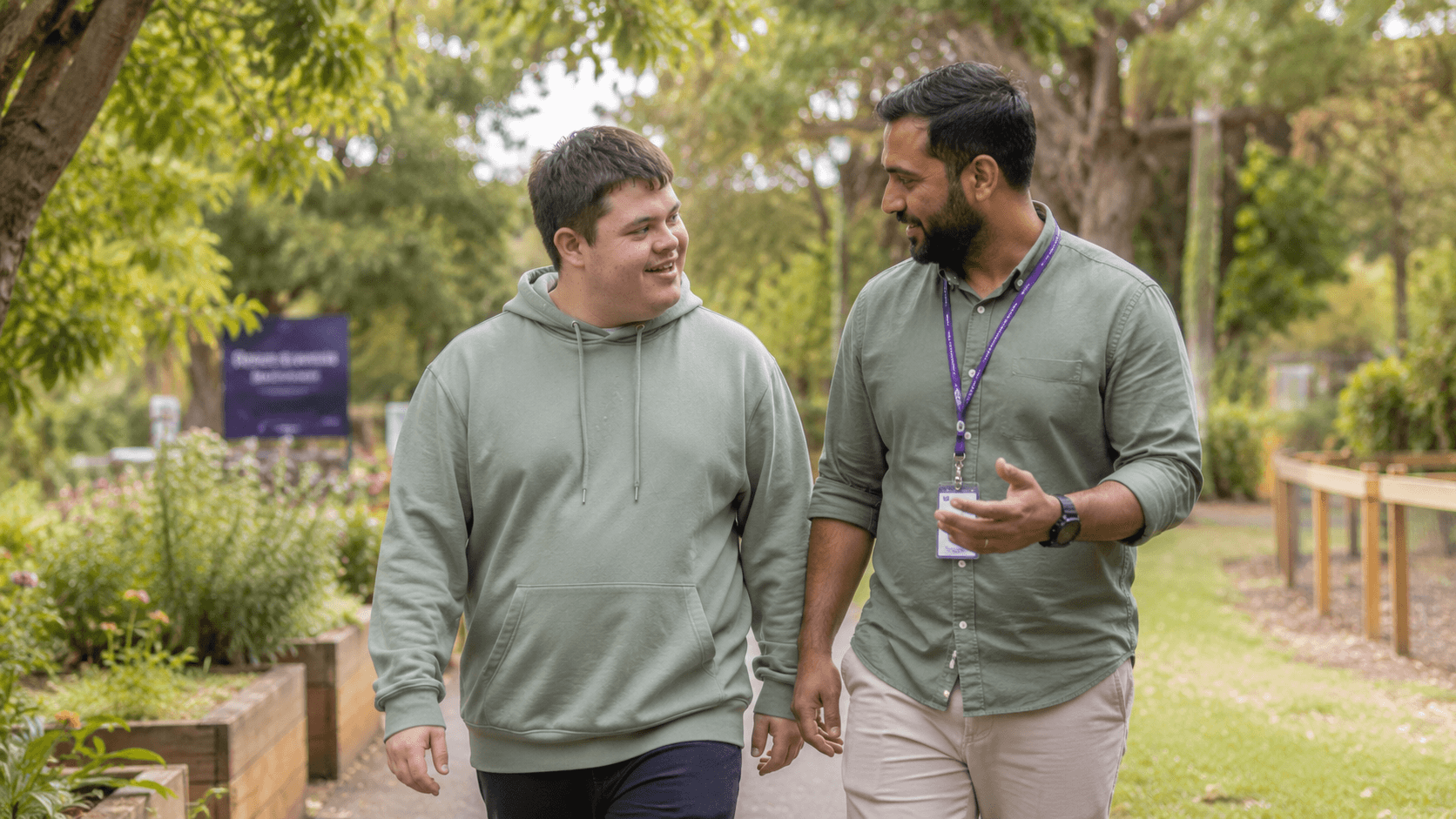 A support worker walking and talking with a participant in a garden
